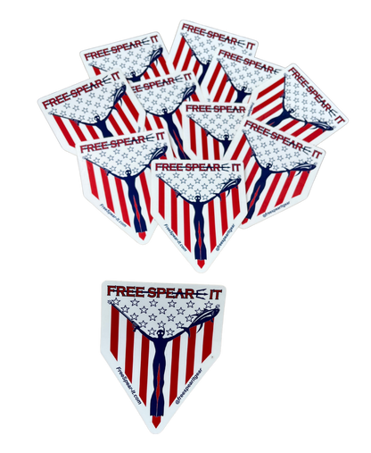 Free Spear-It "Spear-It of Freedom" 4-inch sticker featuring a bold red, white, and blue design with a freediver holding a speargun and fish against an American flag backdrop.  The website FreeSpear-It.com and social media handle @freespearitgear are printed along the bottom border of the sticker.